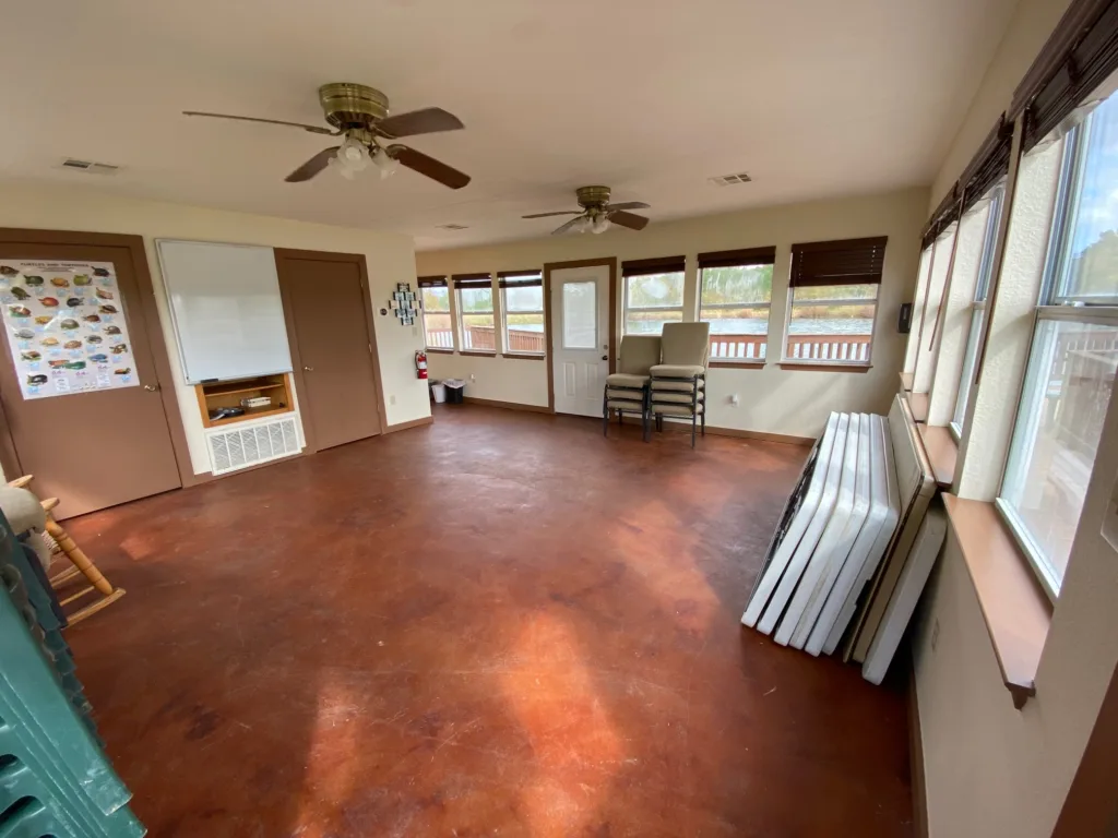 Open meeting room with ceiling fans, bathroom and small kithenette.